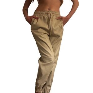 Cream pleather joggers with draw strings and pockets.